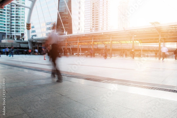 Obraz People are walking at sunset.