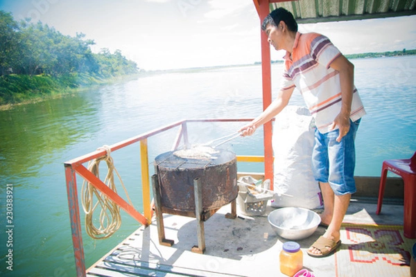 Fototapeta travel man cooking on travel boat