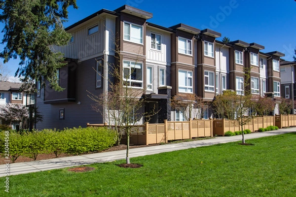 Fototapeta Modern low rise wood frame complex. Brand new apartment building on sunny day in spring.