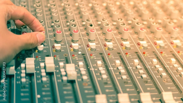 Obraz music mixer with hand adjust the knobs.