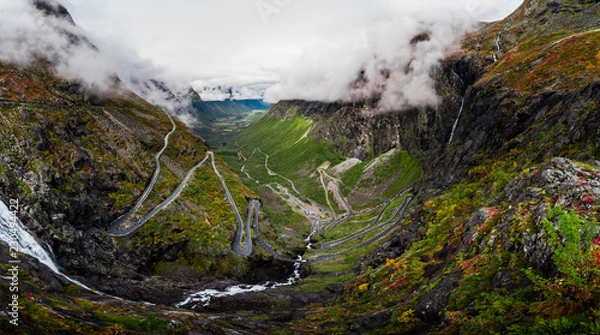 Obraz Aerial Panorama View of Trollstigen Road in Norway with Rushing Waterfall and Mountains and Traffic with Clouds and Fog