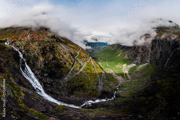 Obraz Aerial Panorama View of Trollstigen Road in Norway with Rushing Waterfall and Mountains and Traffic with Clouds and Fog
