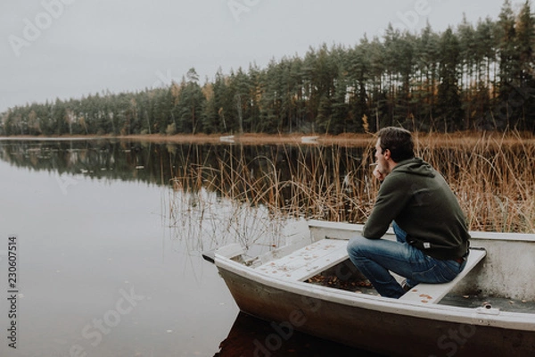 Obraz Einsamer Mann im Ruderboot an einem See im Herbst in Schweden / Lonesome Guy In Skiff At Lake During Indian Summer in Sweden