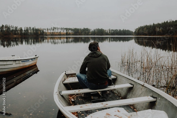 Obraz Einsamer Mann im Ruderboot an einem See im Herbst in Schweden / Lonesome Guy In Skiff At Lake During Indian Summer in Sweden