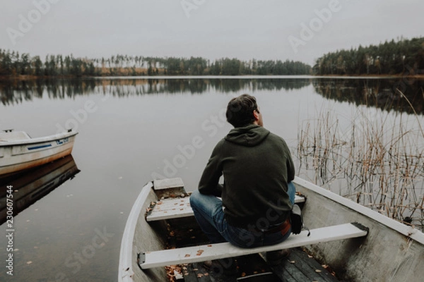 Obraz Einsamer Mann im Ruderboot an einem See im Herbst in Schweden / Lonesome Guy In Skiff At Lake During Indian Summer in Sweden