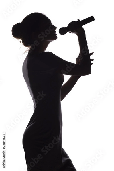 Fototapeta silhouette of girl singing into microphone, profile of young woman face performing lyric song on white isolated background