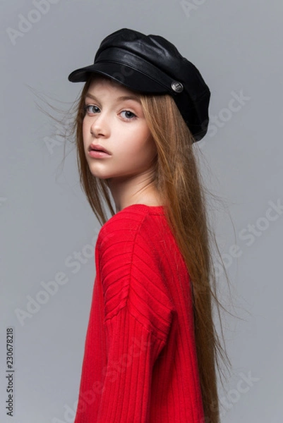 Fototapeta Close-up portrait of beautiful young redhead girl wearing red sweater posing in studio.