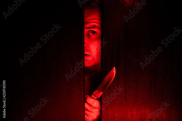Obraz Serial killer / eye peeking behind the door with kinfe