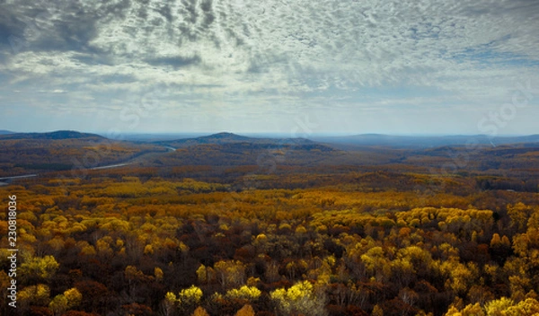 Fototapeta Multicolored autumn forest, mountains and sky with clouds.