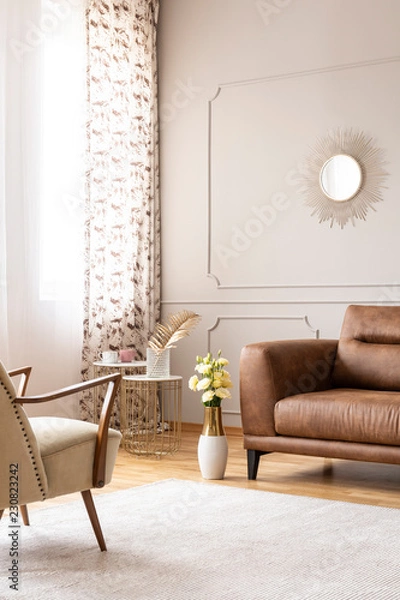 Fototapeta Real photo of bright living room interior with white carpet, window with curtains and fresh roses in vase placed by leather brown sofa