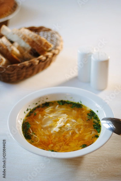 Obraz Soup at white ceramic plate at the table.