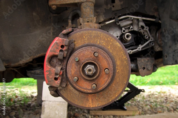 Fototapeta rusty brake disc on a broken car in the yard