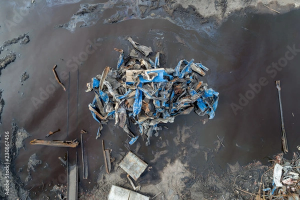 Fototapeta Pile of Twisted Scrap Metal in an Oily Puddle