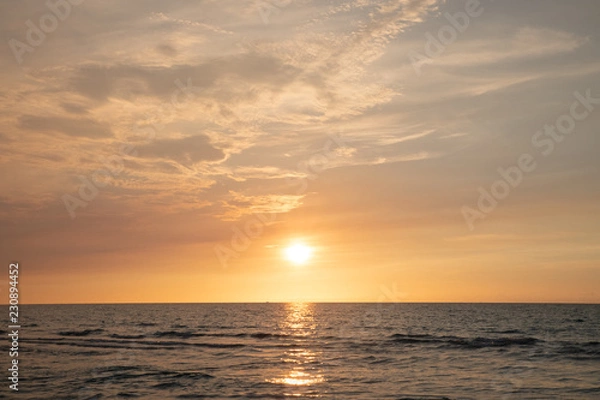 Fototapeta sandy beach by the ocean at sunset
