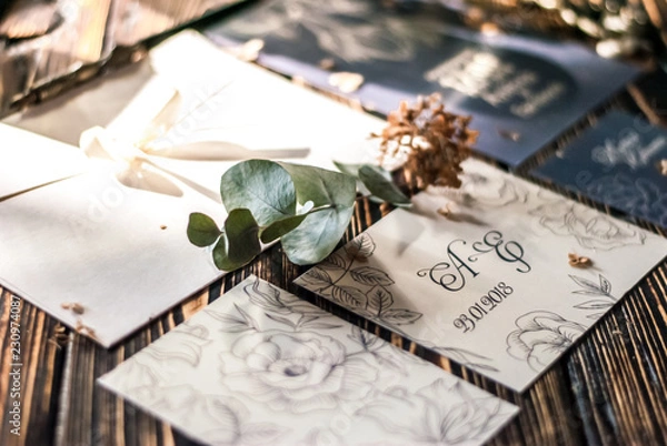 Obraz Свадебные пригласительные. Составные свадебные пригласительные на деревянном столе. Конверт для пригласительных. Веточка эвкалипта