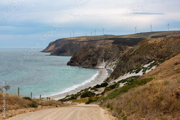 Fototapeta A landscape photo of Morgans Beach Cape Jervis showing the gravel access road and the starfish windfarm in the distance located in South Australia on 1st November 2018