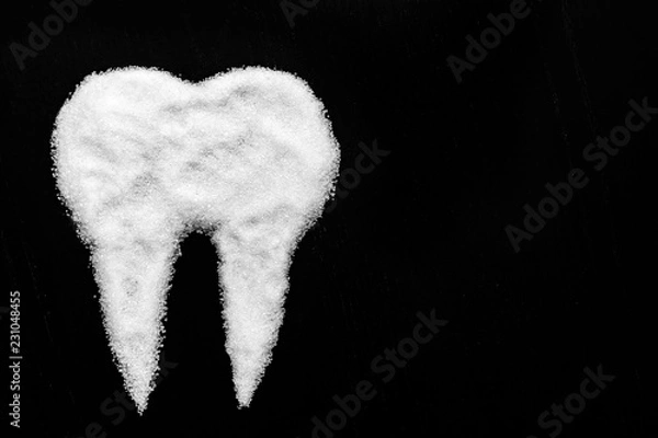 Fototapeta tooth made of sugar on a black background
