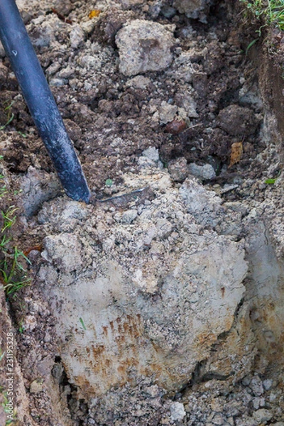 Fototapeta Man digging a ditch with a shovel in autumn