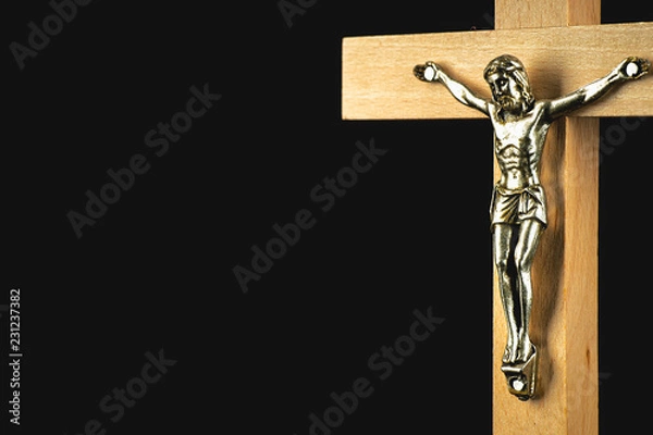 Fototapeta A fragment of a wooden illuminated crucifix against a black background