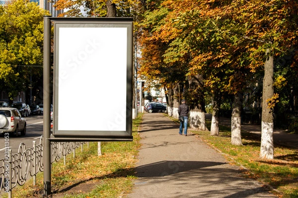 Fototapeta empty white citylight near the pedestrian road. blank vertical billboard on the street during autumn, Blank template.