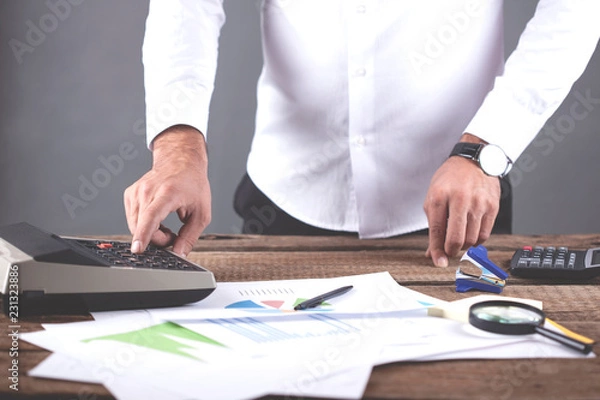 Fototapeta man hand graph with calculator on table