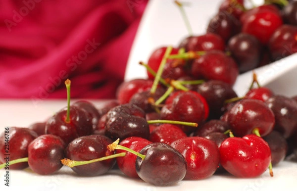 Fototapeta Sweet bing cherries flowing out of a colander