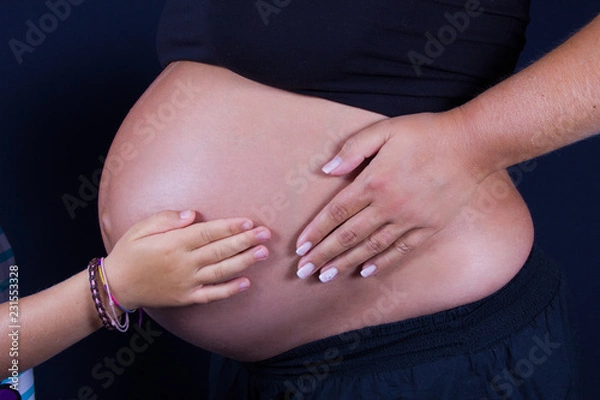 Fototapeta Babybauch mit Händen von Mutter und Schwester