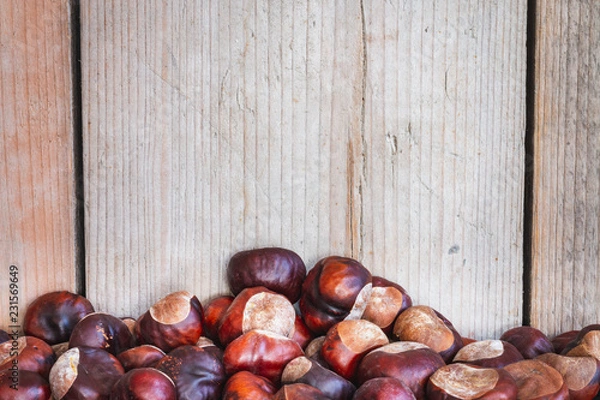 Fototapeta Chestnuts with wooden background