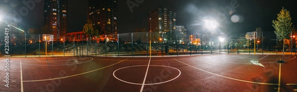 Fototapeta Illuminated basketball playground with red pavement, modern new basketball net and lens flares on background. 