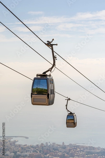 Fototapeta cable car in the mountains against the background of the city