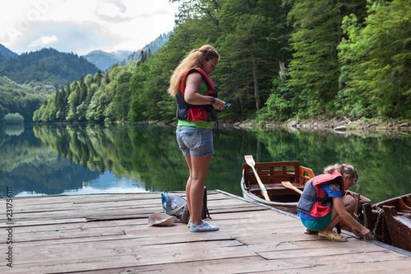 Fototapeta Mom and daughter preparing for boating on Biograd lake. Biogradska Gora national park. Montenegro, Europa