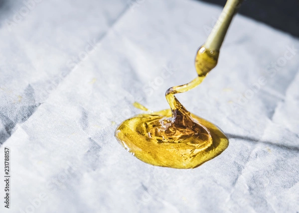 Obraz 0.5 gram THC wax concentrate rosin isolated up close on wax paper with dab tool