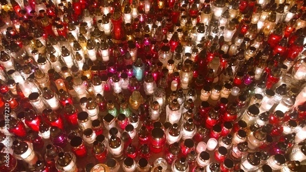 Fototapeta Lots of colourful grave candles shining at night