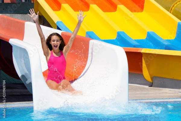 Obraz Joyful teenage girl going down on water slide make the water splashing in the aqua park