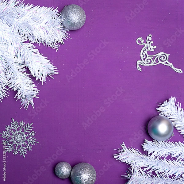 Fototapeta Christmas background with free space. Textural wooden background of bright purple color with white artificial fir branches, artificial snow, sparkles, Christmas balls
