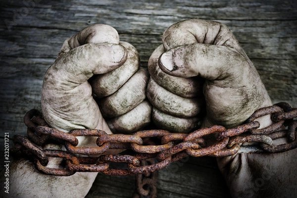 Fototapeta Powerful dirty male hands clenched into fists chained with rusty chain.