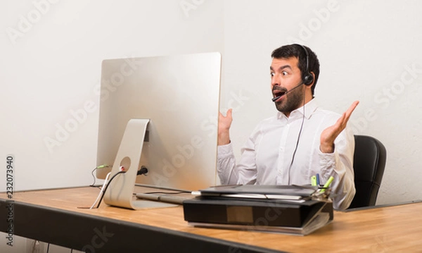 Fototapeta Telemarketer man in a office with surprise and shocked facial expression