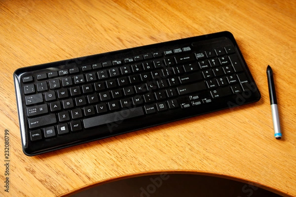 Fototapeta Generic keyboard on a desk with a pen