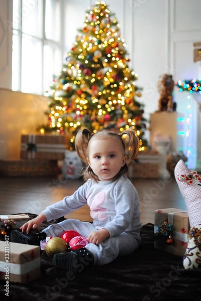 Obraz Ребенок ждет чуда в Новый год. С новым годом! Счастливого Рождества! Новогодняя елка с рождественскими игрушками. Девочка  с подарками.
