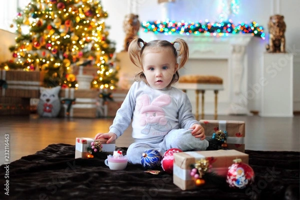 Obraz Ребенок ждет чуда в Новый год. С новым годом! Счастливого Рождества! Новогодняя елка с рождественскими игрушками. Девочка  с подарками.
