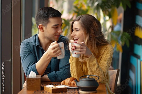Obraz Młoda para zakochanych siedzi w kawiarni, picia kawy