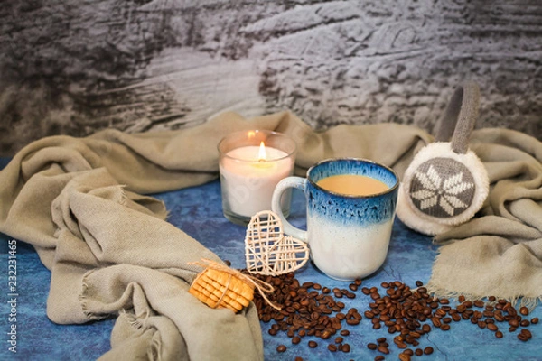 Fototapeta Autumn and winter background with candle, scarf, mug of cocoa, coffee or hot chocolate with scattered coffee beans
