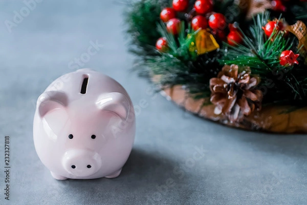 Fototapeta Pink pig and a Christmas wreath on a gray background. Concept of Christmas and New Year. Eastern New Year.