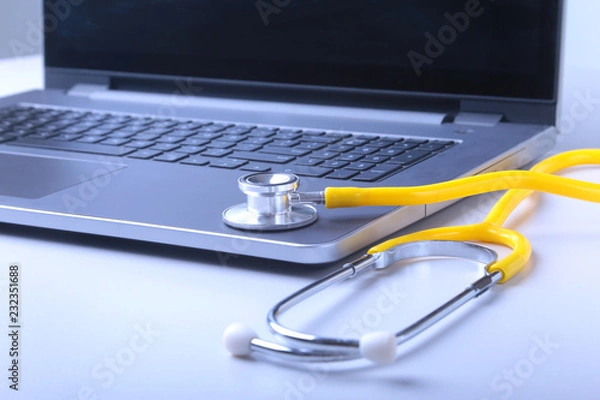 Fototapeta Workplace of doctor with laptop, stethoscope and RX prescription on white table. top view.