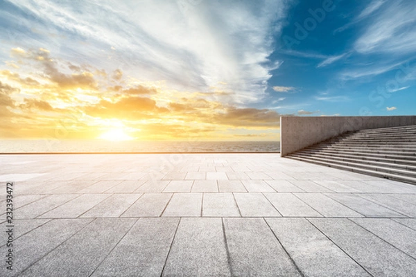 Fototapeta Empty square floor and dramatic sky with coastline at sunset