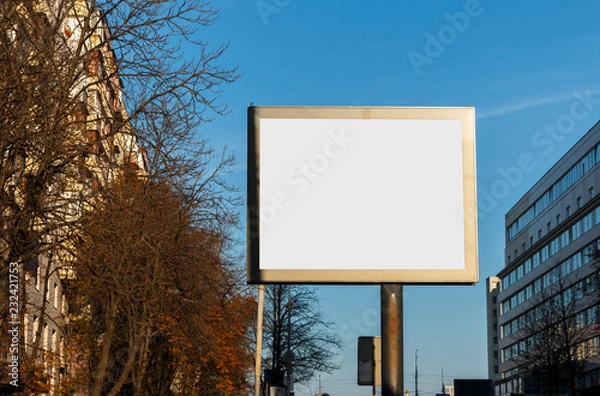 Obraz The big white billboard in the city during day time. Billboard mock-up on the blue sky and city background.