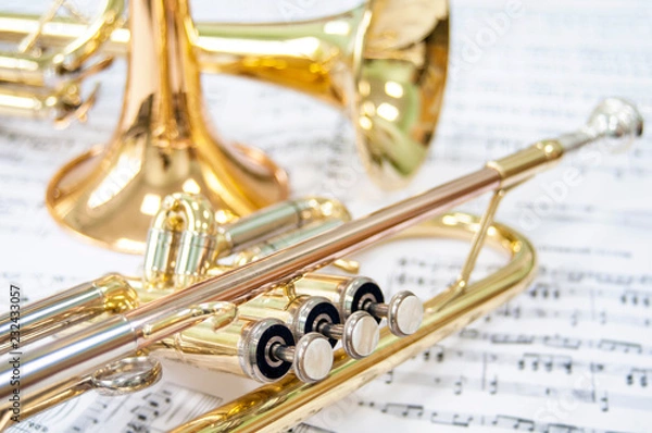 Fototapeta Still life. Three golden trumpets. Two lie on the notes and one trumpet stands. Brass Trio.