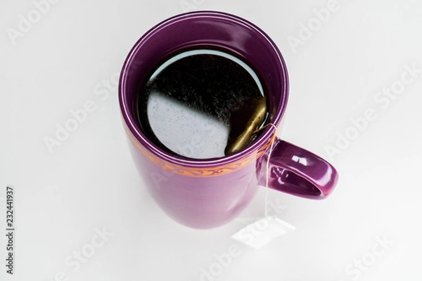 Fototapeta Filled cup of tea with tea bag from top