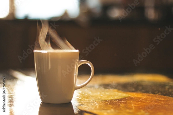 Obraz Close up of steaming cup of coffee or tea on vintage table - early morning breakfast on rustic background