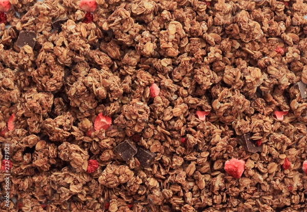 Fototapeta Chocolate muesli breakfast background. Organic crunchy homemade chocolate granola cereal with oats and berries. Oatmeal chocolate granola texture, top view, flat lay.